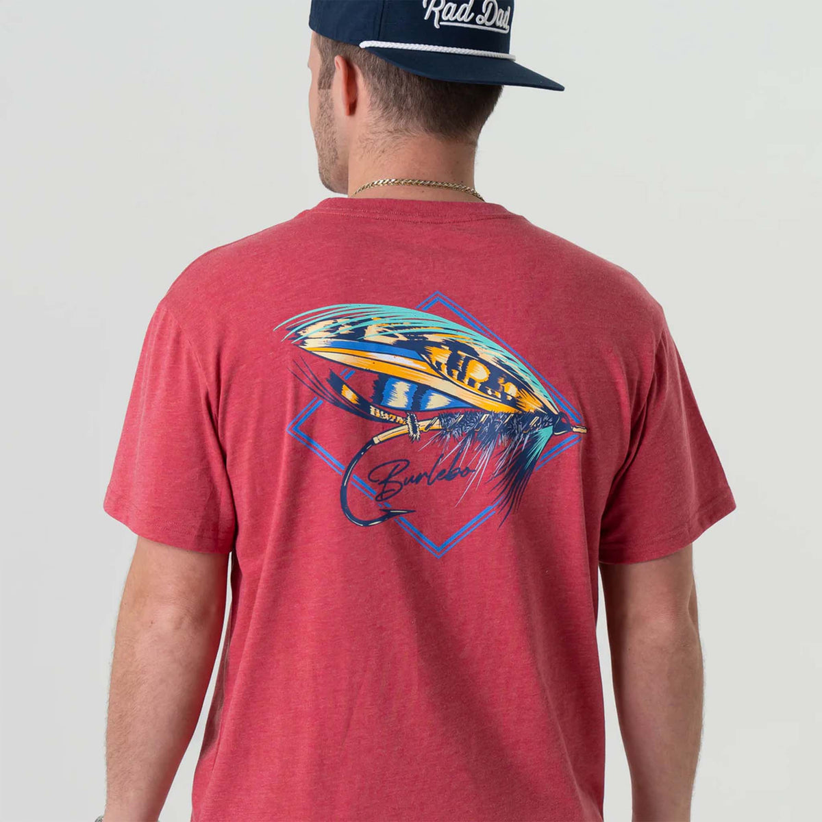 Back view of man wearing Burlebo short sleeve Big Fly t-shirt in heather crimson.  The design features a brightly colored fly-fishing lure with Burlebo&#39;s logo under.   Made from a preshrunk blend of 50% Ring-Spun Cotton and 50% Polyester, this tee offers the perfect combination of softness and durability.