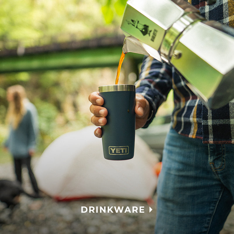 man pouring a cup of coffee into a yeti tumbler