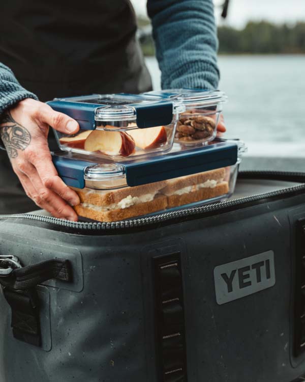 yeti food storage containers being put into a yeti cooler