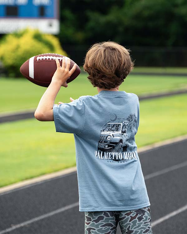 young boy throwing a football