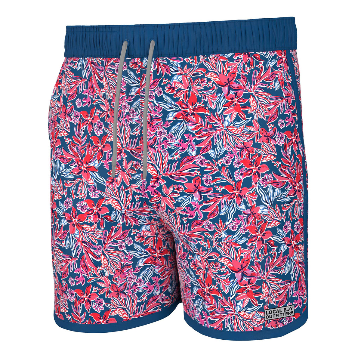 Front view - Local Boy Outfitters Wando swim trunks, color Tropical USA, Sizes S-XXL, 95% Nylon, 5% Elastane.  The Tropical USA pattern has a navy blue background with shades of red, blue, and white creating a tropical floral pattern.  These trunks feature a mesh liner, Elastic waistband with drawstring, two side pockets, and one back pocket with snap button closure. There is a small Local Boy Outfitters logo on the bottom left pant leg.