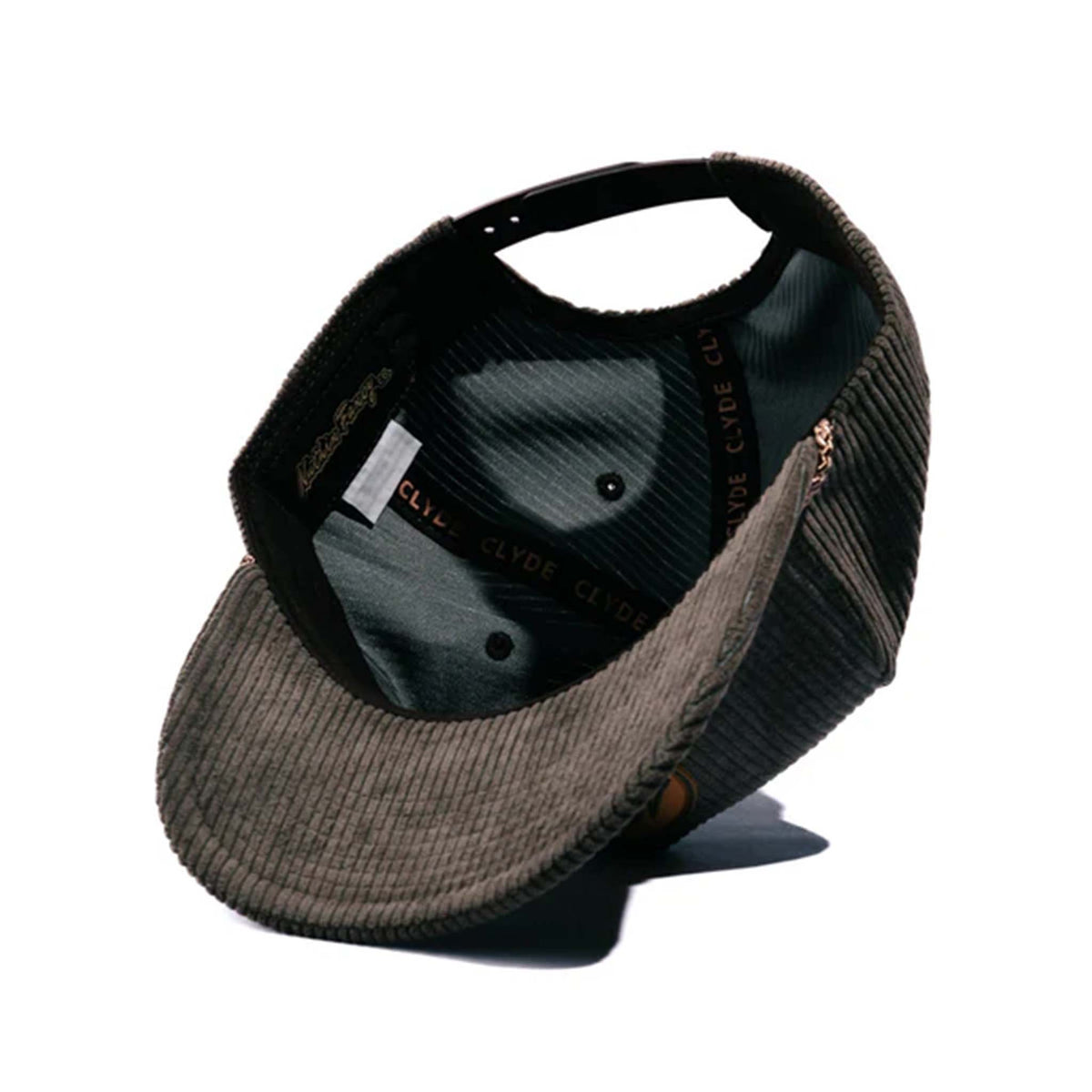 Tan corduroy snapback hat with a slightly curved bill and a brown and tan rubber &#39;Nuthin’ Fancy&#39; logo patch on the front. Features a decorative rope detail above the bill and an adjustable plastic snap closure. One size fits most (58 cm).