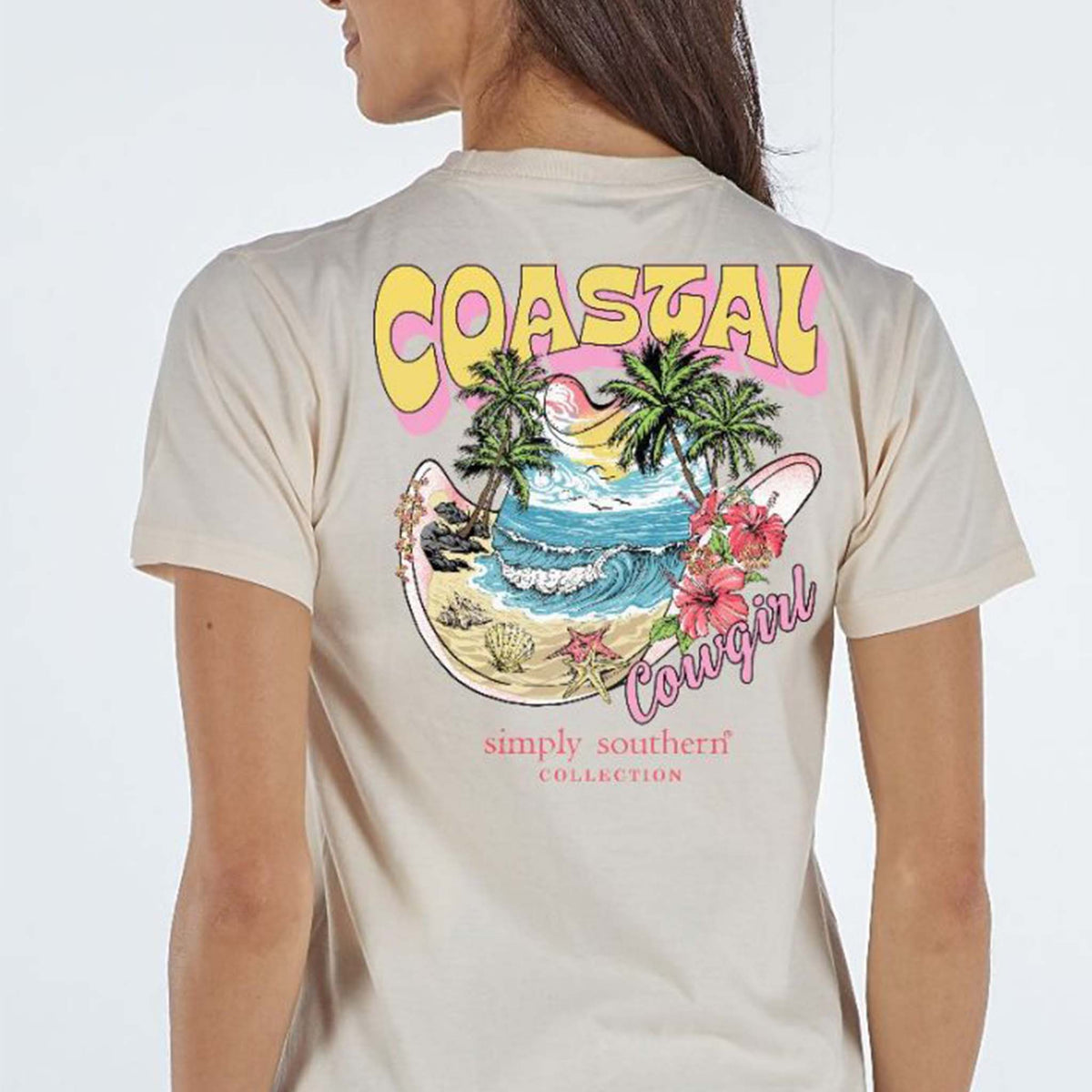 Woman wearing Simply Southern Coastal Cowgirl short sleeve t-shirt featuring the phrase &#39;Coastal cowgirl&#39;, a cowgirl hat with beach, palm trees, and hibiscus flowers. Simply Southern logo below.  Sizes S-XXL